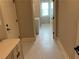 Hallway with laundry room, white cabinets, marble floors, and neutral paint at 1790 Nestledown Dr, Cumming, GA 30040