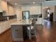 Kitchen island with stainless appliances, granite countertops, and dark wood at 1790 Nestledown Dr, Cumming, GA 30040