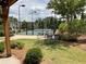 Outdoor pickleball court with green grass, mature trees, and black fencing at 1790 Nestledown Dr, Cumming, GA 30040