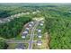 New construction homes in a suburban neighborhood surrounded by lush green trees from an aerial view at 411 Oakleigh Ave, Woodstock, GA 30188