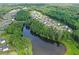 Aerial view of a residential area with houses nestled among trees alongside a tranquil lake at 411 Oakleigh Ave, Woodstock, GA 30188