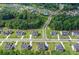 An aerial view of houses, streets, trees, and a pond in a green suburban neighborhood at 411 Oakleigh Ave, Woodstock, GA 30188