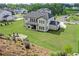 Large, grassy backyard featuring a stone fire pit area and view of the home's rear exterior at 411 Oakleigh Ave, Woodstock, GA 30188