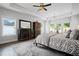 Light bedroom with tray ceilings, a ceiling fan, sitting area, and natural light at 411 Oakleigh Ave, Woodstock, GA 30188