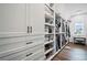 Spacious walk-in closet with custom shelving, drawers, and a vanity area at 411 Oakleigh Ave, Woodstock, GA 30188