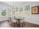 Bright dining area with a modern light fixture and scenic views through large windows at 411 Oakleigh Ave, Woodstock, GA 30188