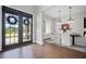 Elegant dining room features hardwood floors, decorative chandeliers, and natural light from the front doors at 411 Oakleigh Ave, Woodstock, GA 30188
