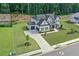 Aerial view of home with landscaped yard, long driveway, patio with fire pit and wooded area at 411 Oakleigh Ave, Woodstock, GA 30188