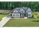 Beautiful two-story home with landscaped yard, white brick, black shutters and an attached two-car garage at 411 Oakleigh Ave, Woodstock, GA 30188