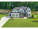 Beautiful two-story home with landscaped yard, white brick, black shutters and an attached two-car garage at 411 Oakleigh Ave, Woodstock, GA 30188
