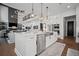 Modern kitchen island with stainless steel appliances adjacent to a living room with high ceilings at 411 Oakleigh Ave, Woodstock, GA 30188