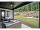 Covered outdoor living area with ample seating and a view of the landscaped backyard at 411 Oakleigh Ave, Woodstock, GA 30188
