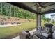 Covered outdoor living area with ample seating and a view of the landscaped backyard at 411 Oakleigh Ave, Woodstock, GA 30188