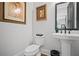Cozy powder room featuring elegant decor and a pedestal sink with modern fixtures at 411 Oakleigh Ave, Woodstock, GA 30188