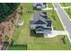 Aerial view of a home featuring a lush backyard, firepit, patio, and driveway at 411 Oakleigh Ave, Woodstock, GA 30188