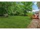 Large grassy backyard with mature trees, lush landscaping, and a storage shed, perfect for outdoor activities at 4200 Sterling Pointe Dr, Douglasville, GA 30135
