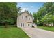 View of home and driveway, surrounded by mature trees and green lawn at 4200 Sterling Pointe Dr, Douglasville, GA 30135