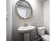 Powder room featuring a pedestal sink, round mirror, and a toilet at 1505 Slopeside Loop, Smyrna, GA 30082
