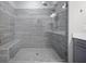 Walk-in shower featuring grey tiling, a glass door, and a built-in bench at 1505 Slopeside Loop, Smyrna, GA 30082