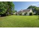 Large, grassy backyard with mature trees at 5832 Sycamore Ridge Dr, Sugar Hill, GA 30518