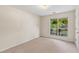 Bright bedroom featuring plush carpeting, neutral walls, and a large window with a view to the yard at 5832 Sycamore Ridge Dr, Sugar Hill, GA 30518