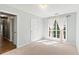 Cozy bedroom with soft carpet, a large window, and ample natural light; doorway to hall visible at 5832 Sycamore Ridge Dr, Sugar Hill, GA 30518