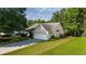 Charming single-story home features a two-car garage, well-manicured lawn, mature trees and landscaped front yard at 5832 Sycamore Ridge Dr, Sugar Hill, GA 30518