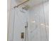 Close up of a modern shower with marble tiles and gold shower head and fixtures at 7535 Antique Barn Ave, Cumming, GA 30041