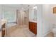 Bathroom with glass enclosed shower, soaking tub, and wood cabinets at 7535 Antique Barn Ave, Cumming, GA 30041