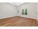 Large bedroom with wood floors, bright window, access to porch, and a modern chandelier at 7535 Antique Barn Ave, Cumming, GA 30041