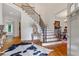 Elegant foyer with hardwood floors, staircase with iron balusters, and stylish decor, creating a grand entrance at 7535 Antique Barn Ave, Cumming, GA 30041