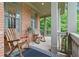 Inviting front porch with rocking chairs, brick accents and decorative rug, creating a cozy outdoor space at 7535 Antique Barn Ave, Cumming, GA 30041