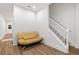 Hallway with hardwood floors, a futon, staircase with white railings, and a door to the outside at 7535 Antique Barn Ave, Cumming, GA 30041