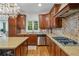Spacious kitchen with dark wood cabinetry, granite countertops, stainless steel appliances, and tile backsplash at 7535 Antique Barn Ave, Cumming, GA 30041