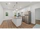 Bright kitchen boasts stainless appliances, white cabinets, granite countertops, and an island with pendant lighting at 7535 Antique Barn Ave, Cumming, GA 30041