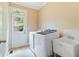 Well-lit laundry room with new washer, dryer, utility sink and access door to the exterior at 7535 Antique Barn Ave, Cumming, GA 30041