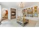 Cozy living room with a stone fireplace, chandelier, carpet, and elegant decor, perfect for relaxation and entertaining at 7535 Antique Barn Ave, Cumming, GA 30041