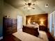 Comfortable bedroom featuring wood accent wall, ceiling fan, and access to bathroom at 112 Countryside Ct, Woodstock, GA 30189