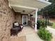 Cozy front porch with brick accents, featuring a seating area and decorative garden ornaments at 112 Countryside Ct, Woodstock, GA 30189
