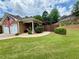 Charming home showcasing a manicured front lawn, brick facade, and double garage at 112 Countryside Ct, Woodstock, GA 30189
