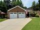 Two-car garage with white doors, set in a well-maintained lawn with an American flag at 112 Countryside Ct, Woodstock, GA 30189