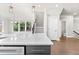 View of the kitchen island with white countertops, sink and modern dishwasher, and access to the powder room at 4020 Townsend Ln, Atlanta, GA 30346