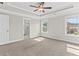 Large primary bedroom with tray ceiling, ceiling fan, carpeted floors, windows and ensuite bathroom and walk in closet at 4020 Townsend Ln, Atlanta, GA 30346