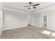 Large primary bedroom with tray ceiling, ceiling fan, carpeted floors, windows and ensuite bathroom and walk in closet at 4020 Townsend Ln, Atlanta, GA 30346