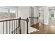 Elegant staircase with hardwood floors and iron railings leading to the upper level with lots of natural light at 4020 Townsend Ln, Atlanta, GA 30346