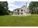 Spacious backyard featuring a well-maintained lawn and a classic white two-story home with a brick chimney at 6625 Eagle Pt, Suwanee, GA 30024