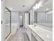 Bathroom with double sink, white vanity, large mirrors, and shower with gold trim at 6625 Eagle Pt, Suwanee, GA 30024
