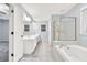 Bright bathroom featuring double sinks, tiled floors, shower and separate soaking tub at 6625 Eagle Pt, Suwanee, GA 30024