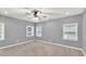 Cozy bedroom with neutral colors, carpet, and ample natural light from three windows at 6625 Eagle Pt, Suwanee, GA 30024