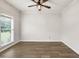 Neutral bedroom with wood flooring, large window, and ceiling fan at 6625 Eagle Pt, Suwanee, GA 30024